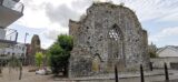 exterior of the front wall of the priory, with the arched window situated in the centre.