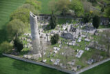 aerial view of a monastic site, with view of the cemetery, round tower, and church.