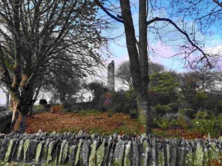 a view of the round tower through the bare-branched trees