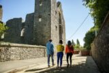 3 people walking up the road toward the ruins of Athlumney Castle.