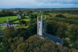 aerial view of the church and graveyard, with a view of the round tower from across the road.