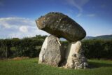 3 standing stones prop up a capstone that sits on top.