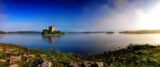 panoramic view of the castle on the lough, the sun reflected in the water.