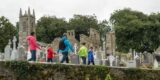 a family of 5 walking through the graveyard of the monastic site