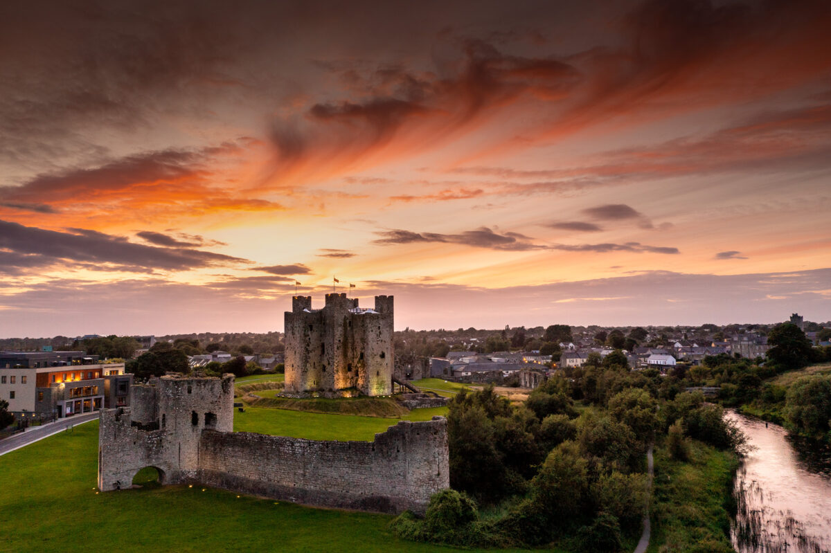 aerial view of trim castle, with a deep orange sunset filling the sky above.