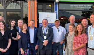 a group of people stand outside a building to pose for a photograph