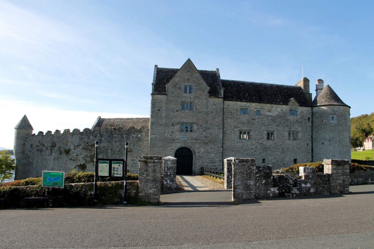 the exterior of the stone castle, which looks more like a large manor house, and the bridged walkway into the entrance.