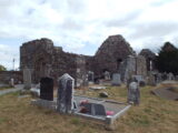 the ruins of a church, with gravestones surrounding the outside