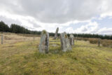 closer view of the standing stones within the stone circle, with an ominous cloudy grey sky above.