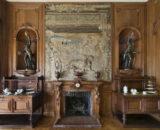 Room within Farmleigh House - a wooden fireplace is in sight with antique furniture on either side, with a canvas painting above the fireplace and sculptures to either side of this.