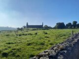 distant view of the roofless church, backlit by a clear blue sky