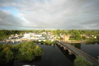 aerial view of a town by the river, with the castle on the right hand side of the bridge