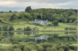 An old church sits in a grassy field.