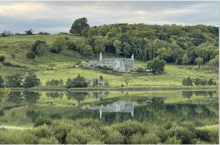 An old church sits in a grassy field.