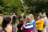 Two women stand in from of a group of people