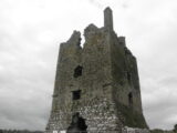 the roofless castle pierces the dark grey sky