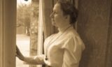 Time Steps in History - black and white image portrays a lady at a window.