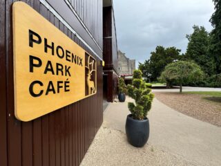 External side view of Phoenix Park Cafe with several potted plants in front of the Café