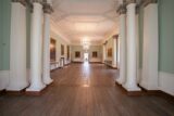 View of Hallway in Rathfarnham Castle which shows pillars,walls with pictures and a splendid chandelier