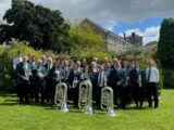 People dressed smartly stand with instruments.