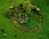 aerial image of the ruins of a church within a walled enclosure