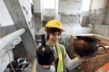 A lady archaeologist holds some uncovered items.
