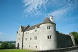 Exterior of the stone castle, which looks more like a large manor house.
