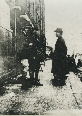 black and white image of Pearse and Elizabeth O'Farrell handing over the surrender letter to General Lowe and his son