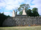 the ruins of a church behind a stone wall