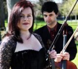 A lady and man with a cello and violin