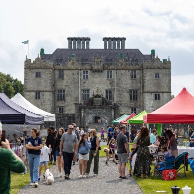 Craft fair with gazebos and people in attendance in front of Portumna Castle