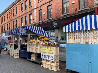 view of the street and the red brick houses, and the market stalls outside them
