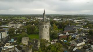 a view of the castle and the surrounding town, with the church spire peeking from behind the castle tower