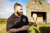 A man holds an owl