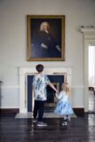 2 Children stand gazing at a piece of art.
