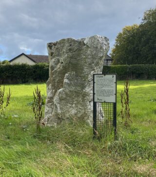 the standing stone with an information notice placed beside it.