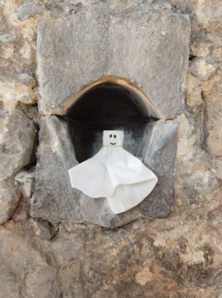 A paper ghost sits in a hole in a wall A paper ghost sits in a hole in a wall