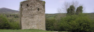the round tower keep backdropped by the distant mountains