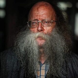 An old man with a large beard and glasses.