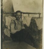 A man sits in a prison cell.