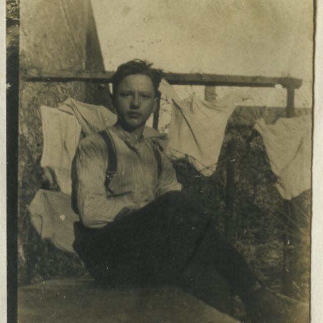 A man sits in a prison cell.