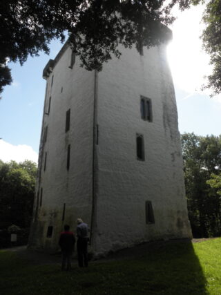 exterior view of the white-painted castle with two people standing outside it