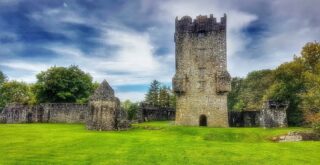 Aughnanure Castle under a dark blue sky