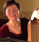 A lady sitting next to her Harp