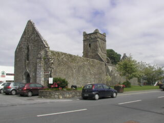 exterior view of the abbey, with cars parked outside