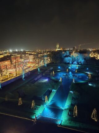 Aerial view of lit up Rose Garden with city buildings in the background, Aerial view of lit up Rose Garden with city buildings in the background,