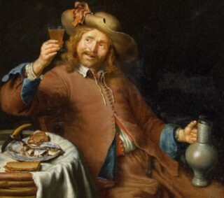 A man sits holding a glass and a pitcher