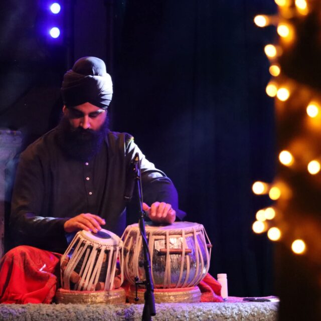 image of a man in a dark room sitting in front of drums