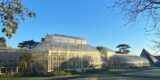 A large Glasshouse under a bright blue sky