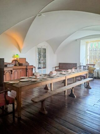 a long dining table under an arched ceiling